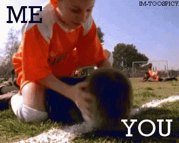 a boy in an orange shirt is petting a dog on a field with the words " me you "