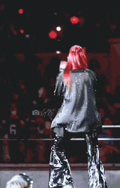 a woman with red hair is standing in a wrestling ring