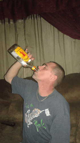 a man is drinking from a bottle of captain morgan rum