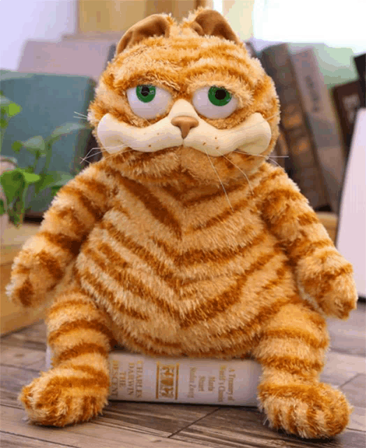 a stuffed cat is sitting on top of a book called a journey of a thousand years