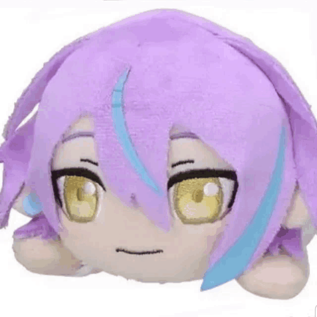 a stuffed animal with purple hair and yellow eyes is laying down on a white surface .