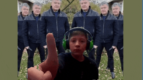 a boy wearing headphones is pointing at the camera