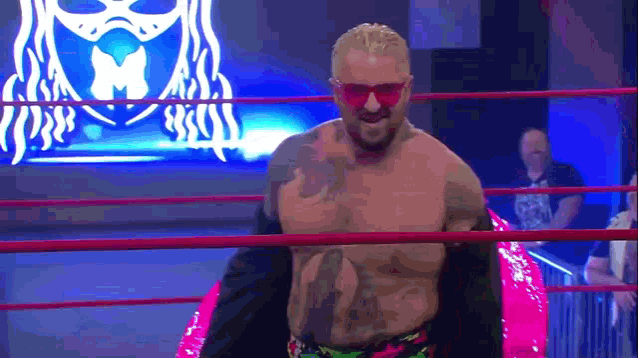 a man in a wrestling ring wearing sunglasses