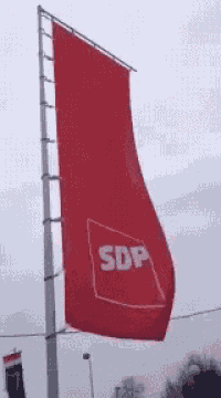 a red flag that says sdp is hanging from a pole