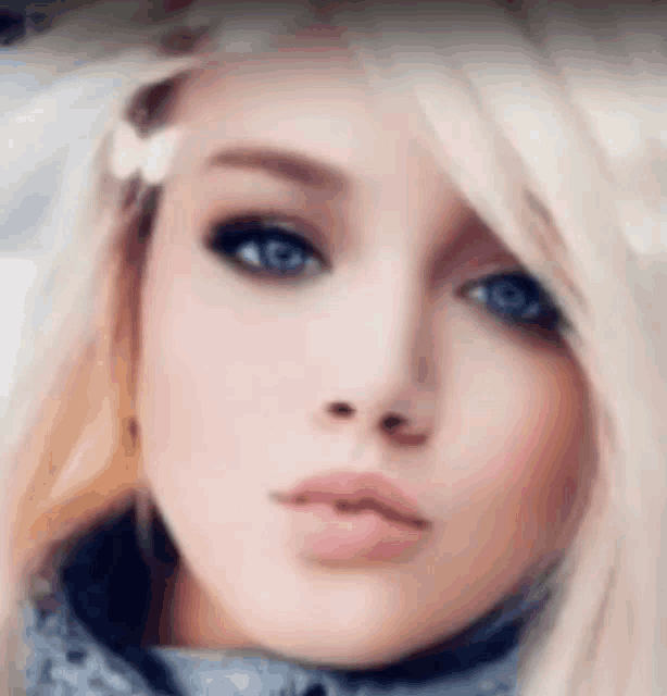 a close up of a woman 's face with blonde hair and blue eyes