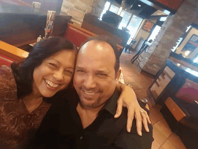 a man and a woman are posing for a picture in a diner