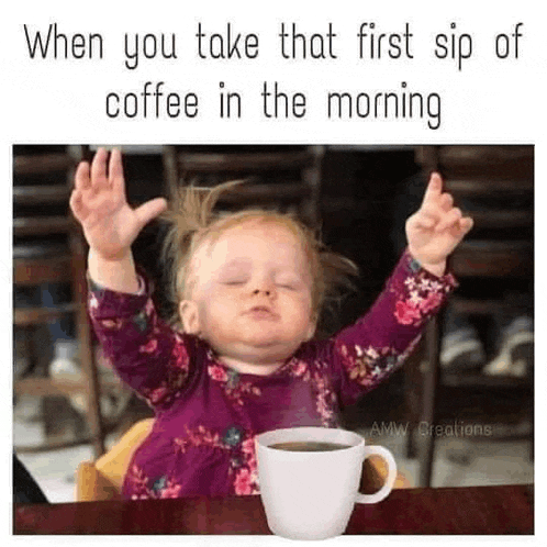 a little girl is sitting at a table with a cup of coffee and her arms in the air .