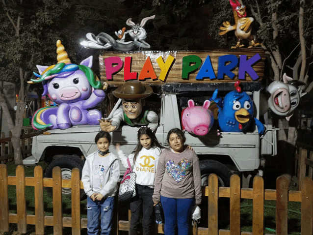 a group of children pose in front of a play park sign