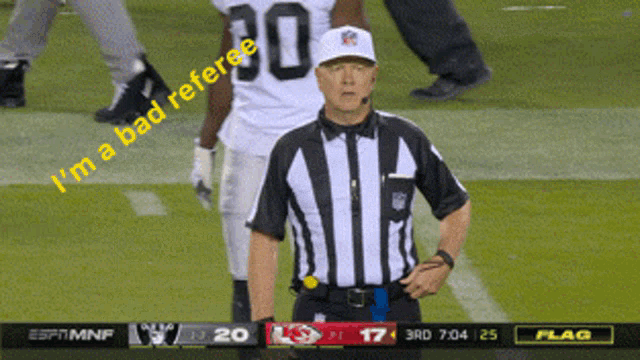 a referee stands on a football field with the words " i 'm a bad referee " on the screen behind him