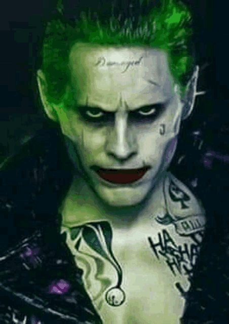 a close up of a person dressed as the joker with green hair and a tattoo on his chest .