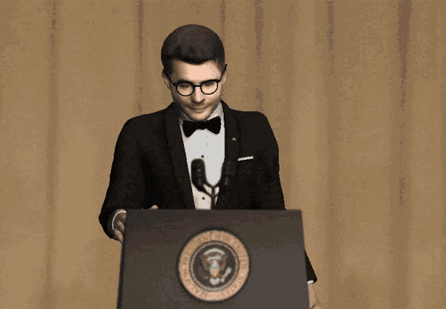 a man in a tuxedo and bow tie stands at a podium with the seal of the president of the united states on it