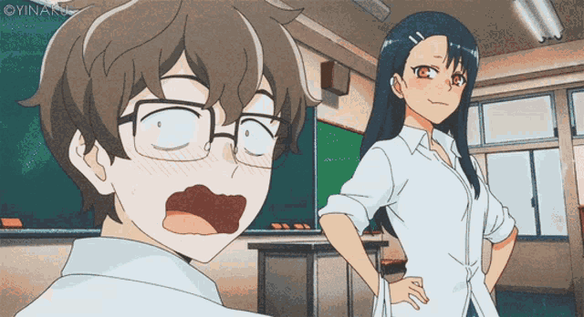 a boy and a girl are standing in a classroom with the girl looking surprised