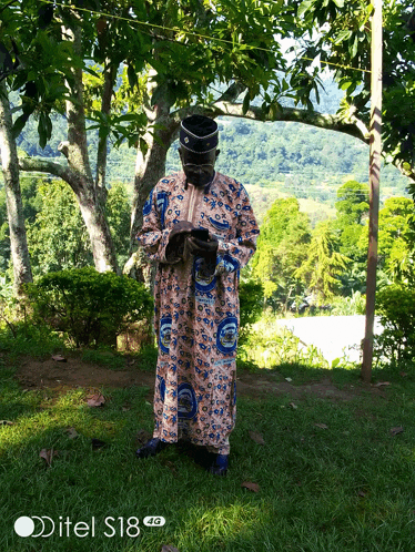 a man standing in a field with a ditel s18 4g phone in the foreground