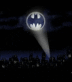 a spotlight is shining on the batman logo in the night sky over a city .