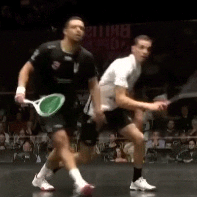 two men are playing squash in front of a crowd and a sign that says ' england ' on it