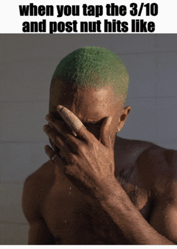 a shirtless man with green hair is covering his face with his hand