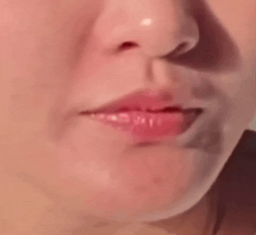 a close up of a woman 's face with her mouth open and her nose visible .