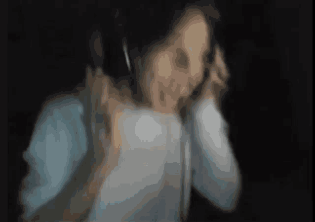 a blurry picture of a person wearing headphones in the dark