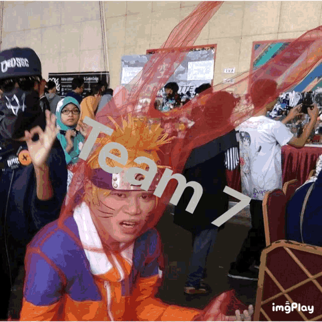 a man in a naruto costume is surrounded by other people and the words team 7 are on the wall behind him