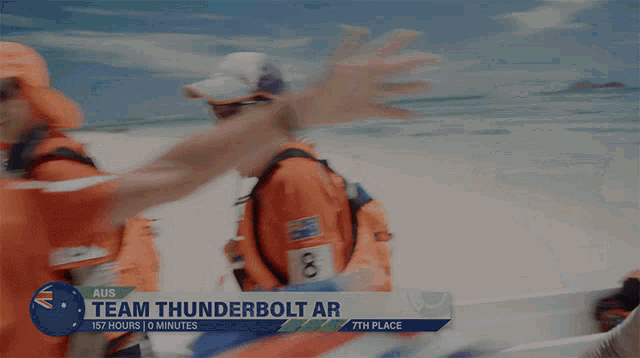 a group of people standing on a beach with a sign that says team thunderbolt ar 157 hours 0 minutes