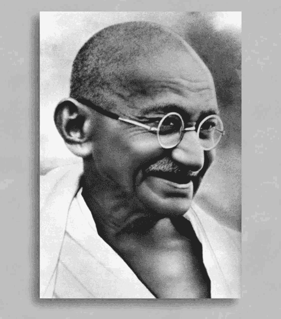 a black and white photo of mahatma gandhi wearing glasses and a white shirt