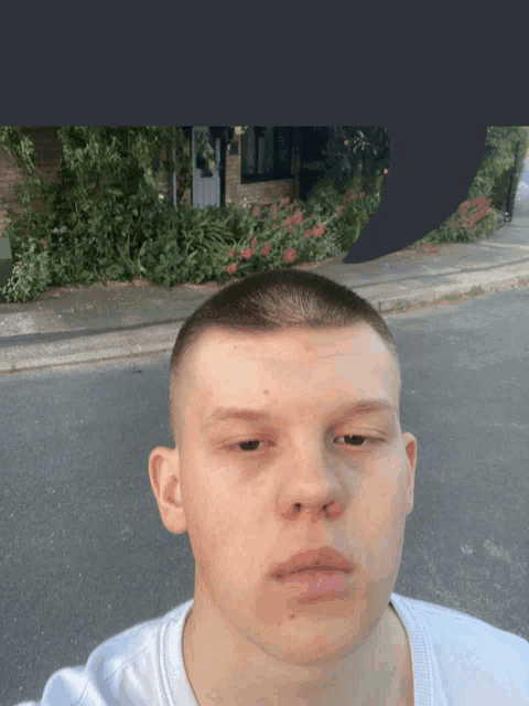 a young man is taking a selfie in front of a house