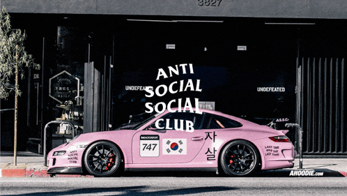 a pink sports car that says anti social social club on the side