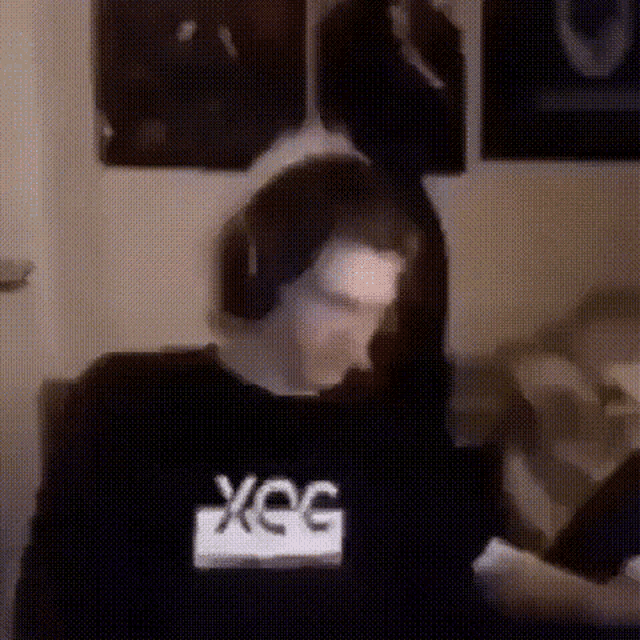 a man wearing headphones and a shirt that says xeg on it