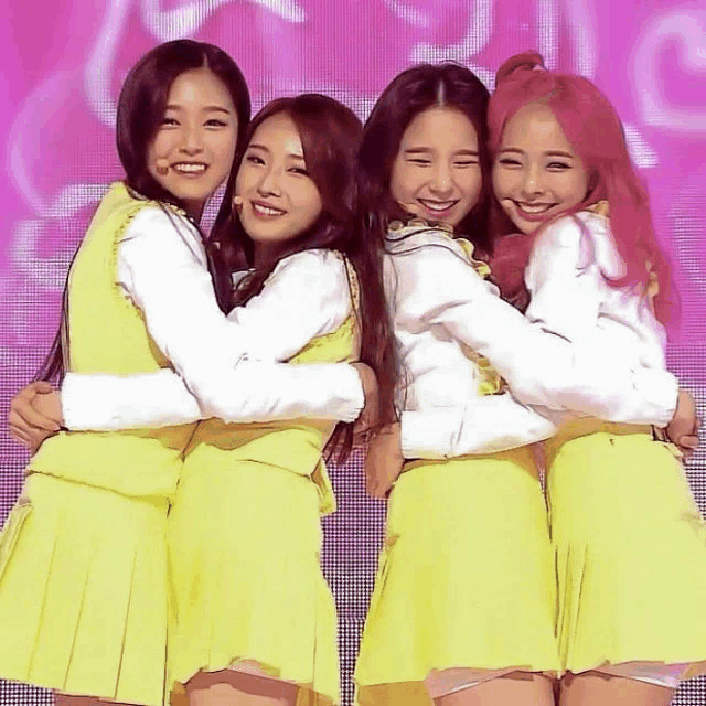 a group of girls are hugging each other and smiling