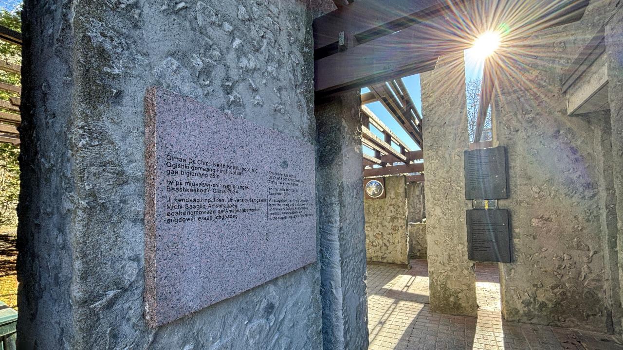 Photo of granite cornerstone on outdoor stone wall with sun beaming on it.