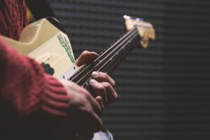 man in red sweater playing a guitar