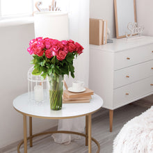 hot pink roses in a glass vase on a table
