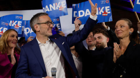 Herbert Kickl (L), leader and top candidate of right-wing populist Freedom Party of Austria (FPOe) is celebrated by supporters at the party's election event after exit poll numbers were announced at t