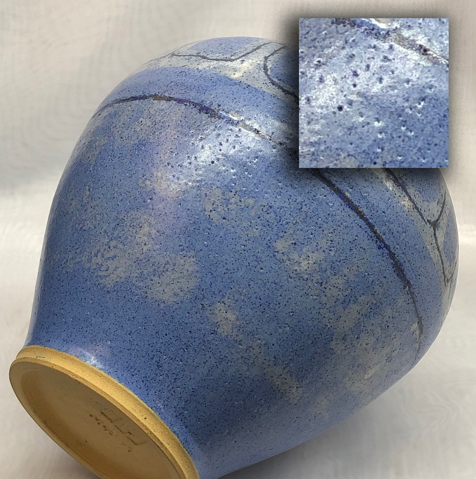 A cone 6 blue silky matte glazed vase with thousands of pinholes in the glaze