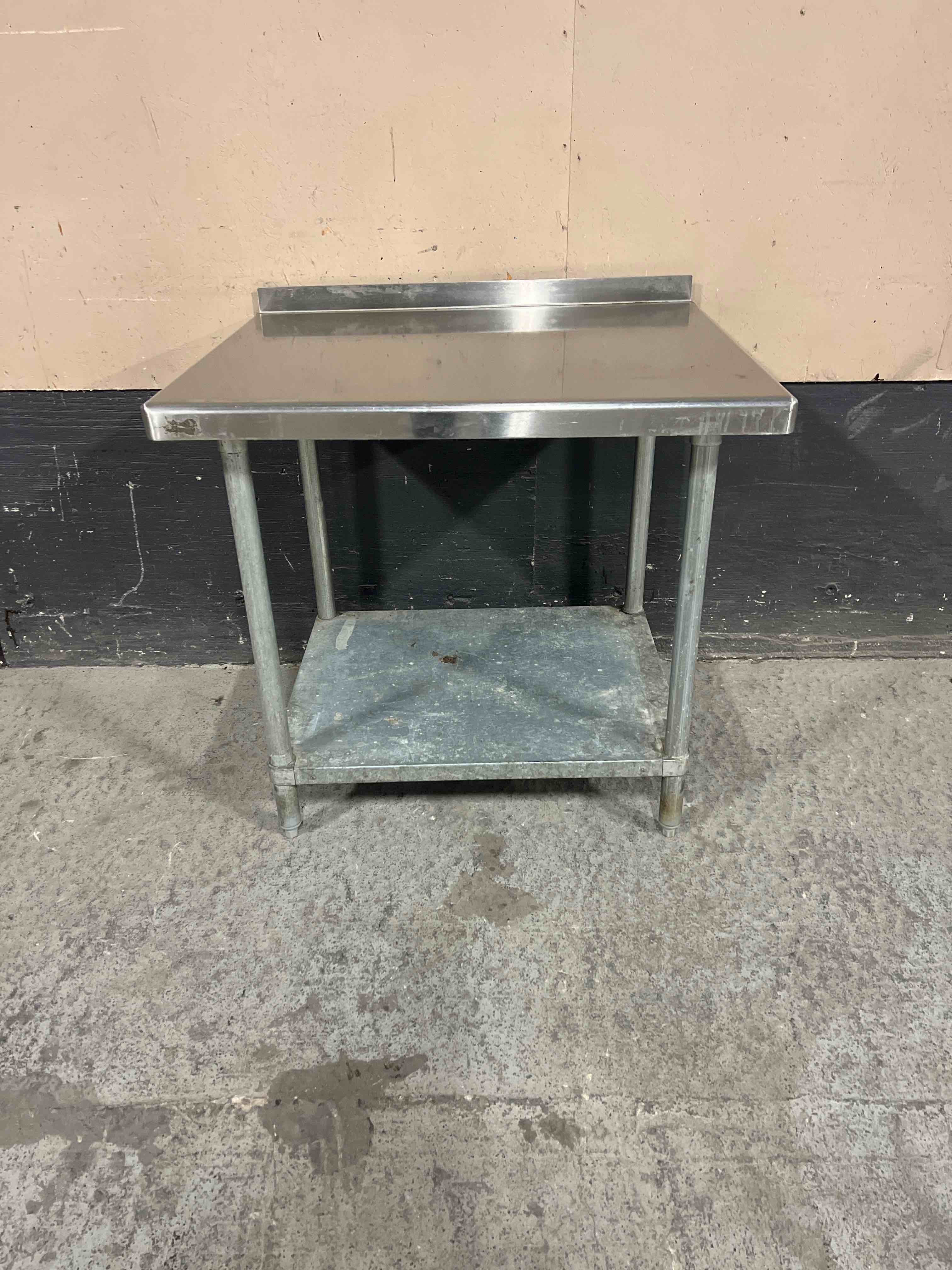 STAINLESS STEEL TABLE WITH GALVANIZED UNDER SHELF AND 2 INCH BACKSPLASH 