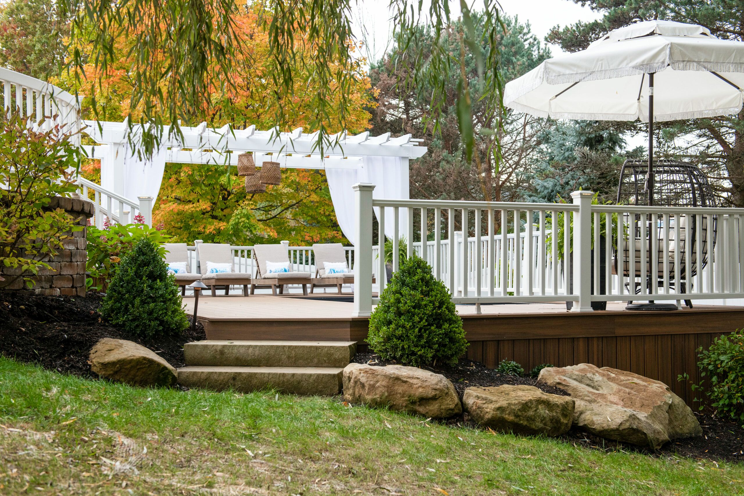 Boulder style landscaping rocks lie around the outside of a pool deck.