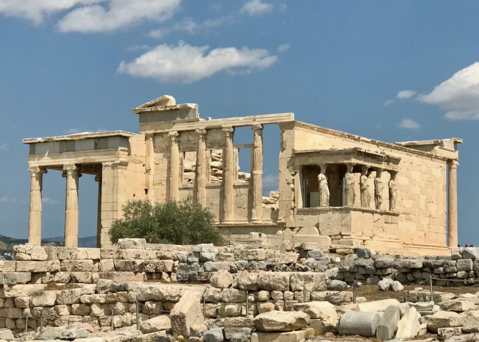 Ruins of a large ancient marble temple against a blue sky