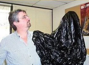 Man with arm in garbage bag - arm is Invisible