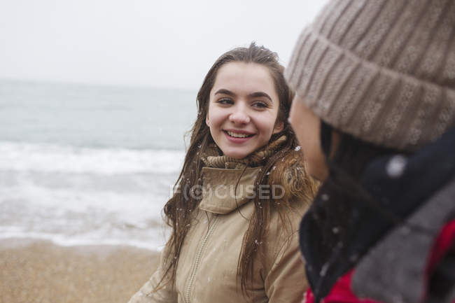 Mutter und Tochter spazieren am verschneiten Winterstrand — Stockfoto