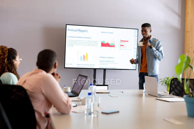 Afrikanisch-amerikanischer junger Geschäftsmann in Kasualien bei einer Präsentation im Sitzungssaal des Kreativbüros. Kreatives Geschäft, modernes Geschäft und Technologie. — Stockfoto