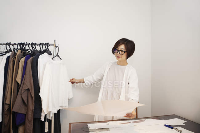 Japanerin mit Brille an einem Schreibtisch in einer kleinen Modeboutique. — Stockfoto