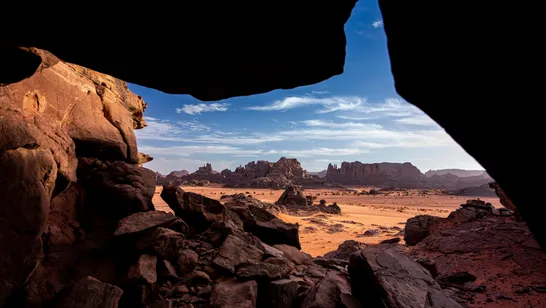 Cette vue capturée depuis l'intérieur d'une grotte présente les formations rocheuses d'Oan Atan, une zone de mésas ...