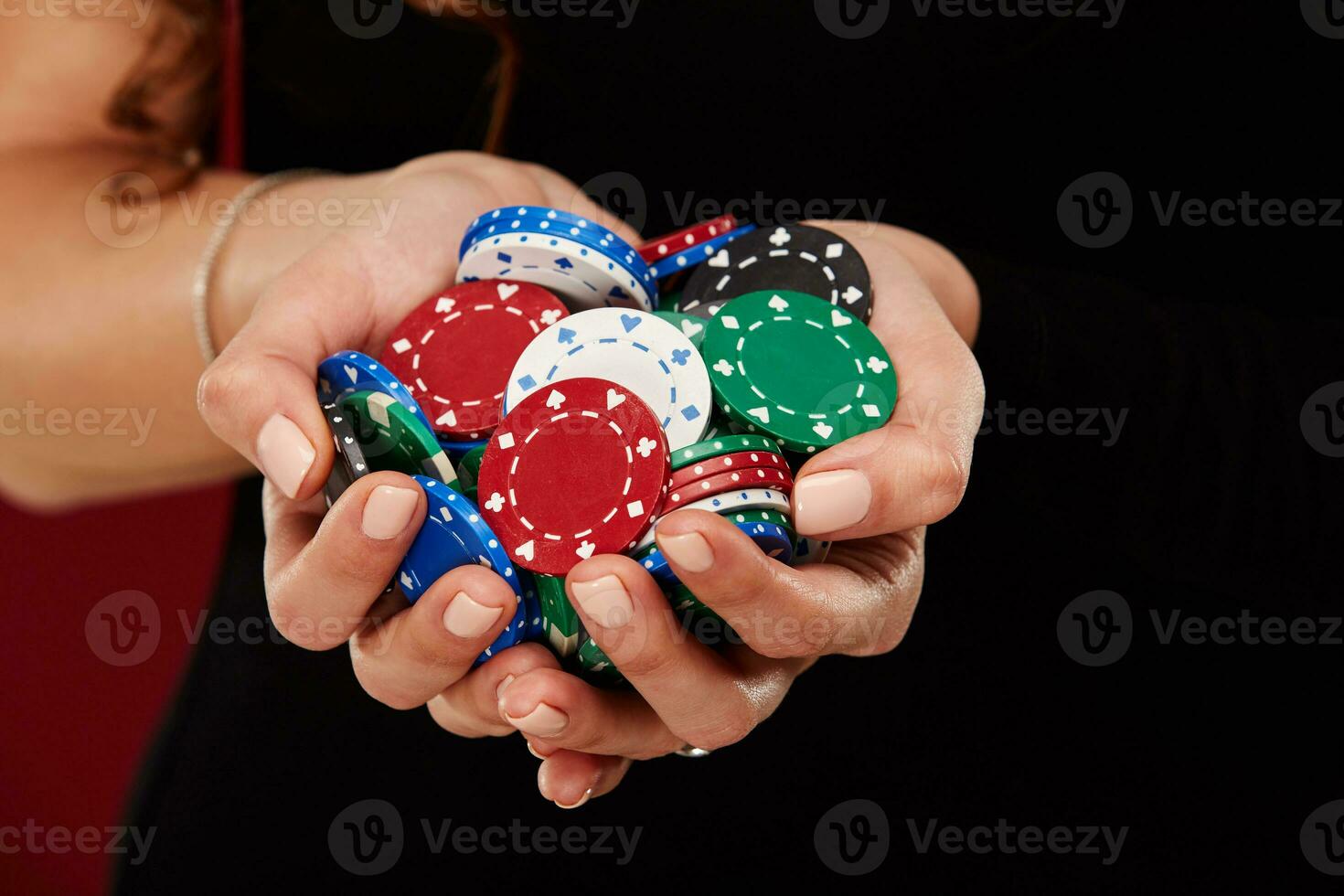 Female Poker player with paint white nails hold her poker chips to make a bet. Gambling and casino business concept photo