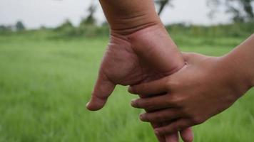 Cerrar la mano del padre sosteniendo la mano de la hija en la escena de cámara lenta video