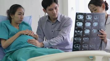 Asian Man and Pregnant Woman Getting Serious News from Doctor. video