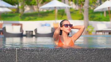 mujer joven disfruta alrededor de la piscina al aire libre video