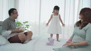 Pregnant Family with Young Daughter Playing teddy Bear Together in Bedroom video