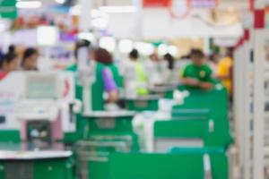 supermarket checkout payment terminal with customers blurred background photo