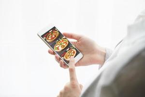 Unrecognizable woman is holding cell phone. View from behind, mockup photo