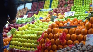 Oranges, apples and other fruits. Shopkeepers are placing apples on the aisle. Oranges and green apples stand out. video